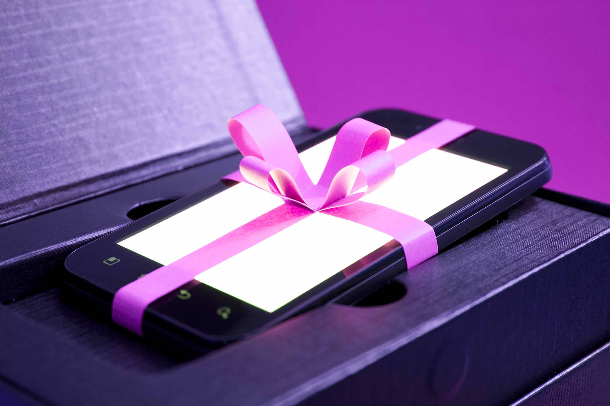 Smartphone mit Schleife als Geschenk